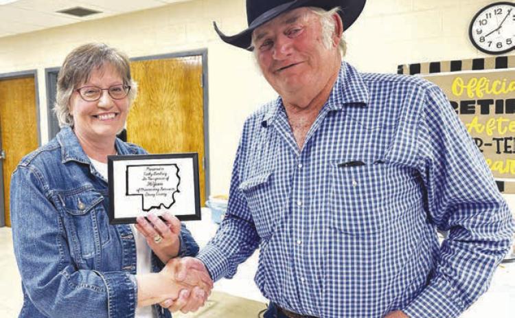 Cathy Lemburg received a plaque from Dewey County Commission Chairman Bob Berndt at a retirement party in her honor on June 19. She also received a star quilt from county employees presented by Highway Supt. Will Wiedmer.