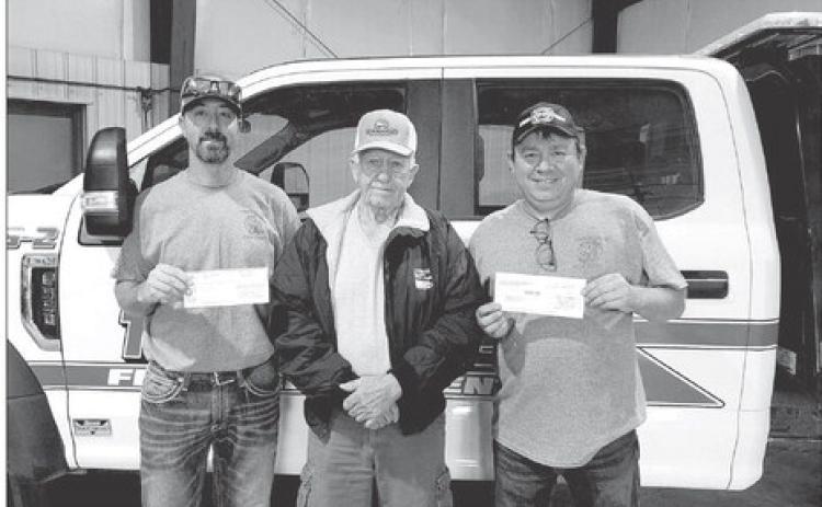 Moreau-Grand board chairman Larry Hieb (MIDDLE) presents a check for $1000 to Jeremy Bollinger (LEFT) and Grady Kraft (RIGHT) of the Timber Lake Volunteer Fire Department.