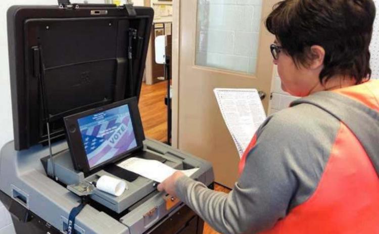 Deputy Dewey County Auditor Cherie Leibel does a test run of ballot tabulating equipment on October 23 in preparation for the November 3 general election. The machine scans and counts the votes on the paper ballots and prints out a ticket to verify the count.
