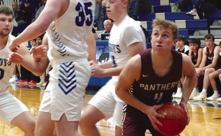 Senior guard Gracen Hansen (4) pump fakes Lemmon defender Sawyer Thompson (35) under the basket during the boys basketball season opener for both teams last Friday, Dec. 8. Timber Lake rallied late but ended up taking a 58-54 loss. Photo courtesy of Marie Du Preez