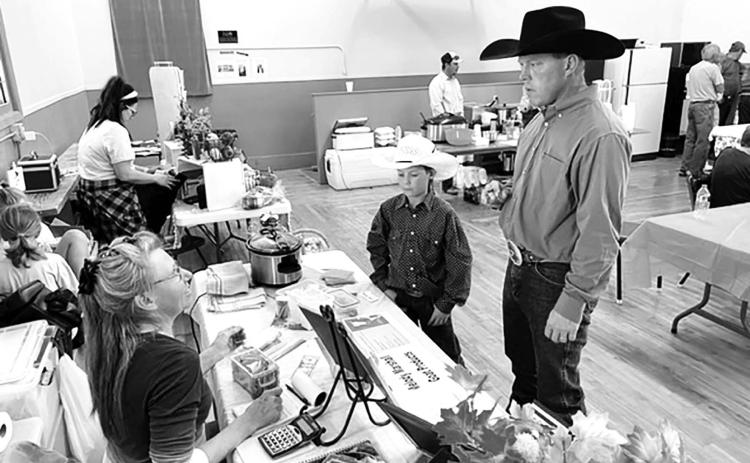 Melody Marshall of rural Timber Lake (LEFT) talks about her goat meat products with Justin Thompson and son of rural Mobridge. Photos by Kathy Nelson